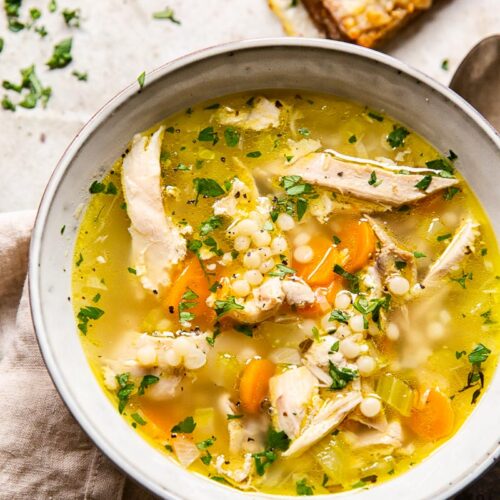 Hearty leftover BC turkey soup with pearl couscous, carrots, and fresh parsley in a light broth